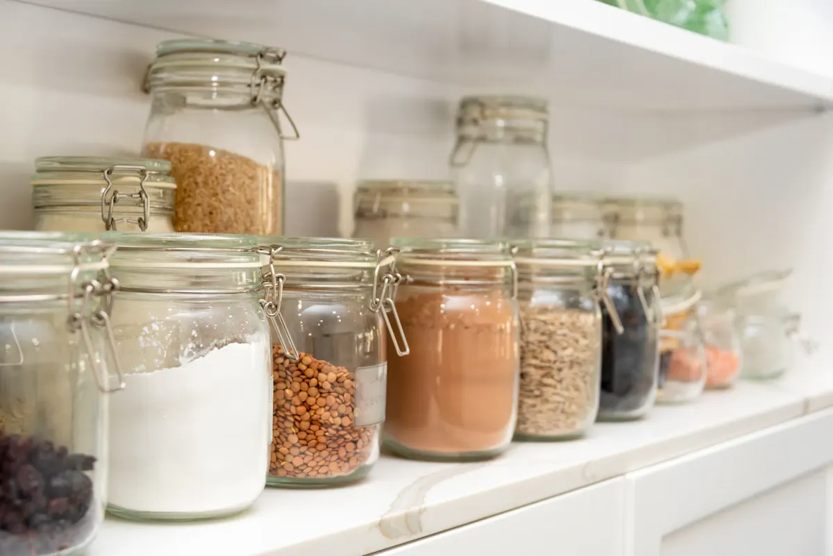 Dry ingredients stored in glass jars on pantry shelving